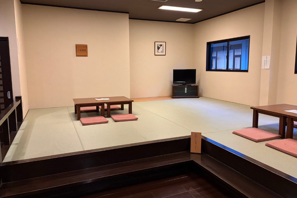 やっぽんぽんの湯の畳の休憩スペース。低いテーブルとクッションが並び、テレビも設置されている